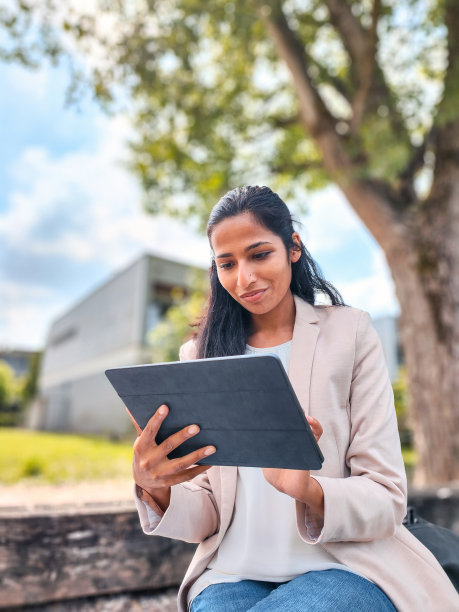年轻的印度女商人在户外用数字平板电脑工作图片下载