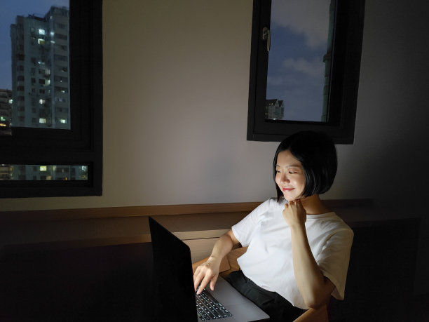 亚洲女性晚上在家用笔记本电脑工作图片下载