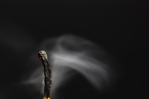 吸烟的火柴棍。特写,黑色背景。图片下载