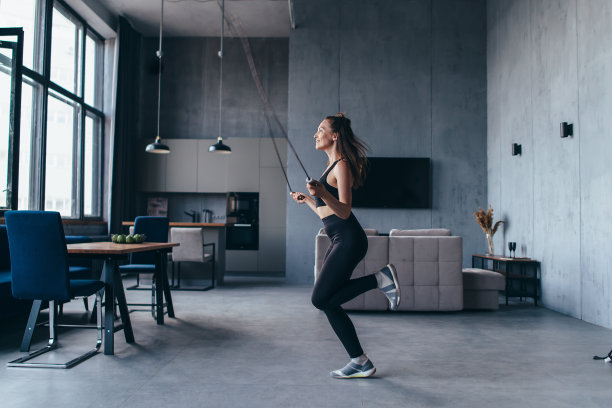 女孩在家用跳绳锻炼身体。健美女子跳绳。图片下载