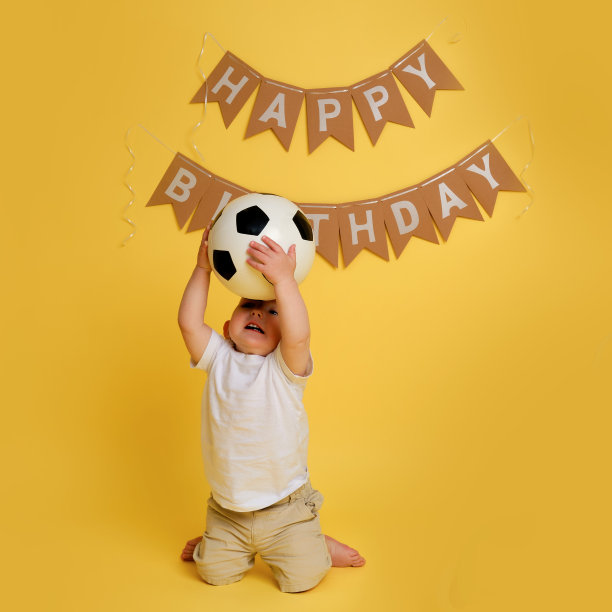 在工作室黄色背景上的装饰是为了庆祝一个孩子的第一个生日，一岁的婴儿图片下载