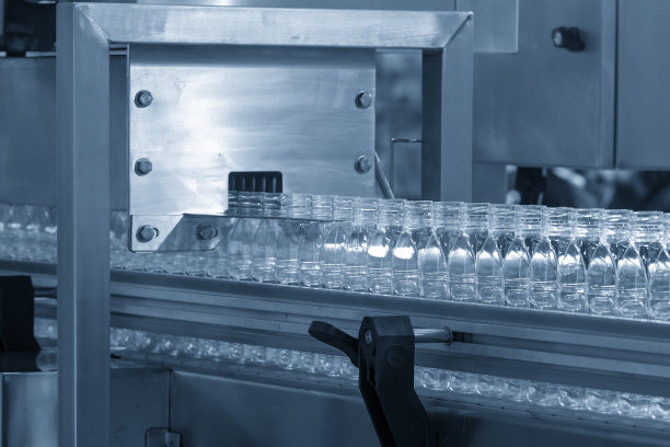 灌装机灌装过程中输送带上的空水瓶。图片下载