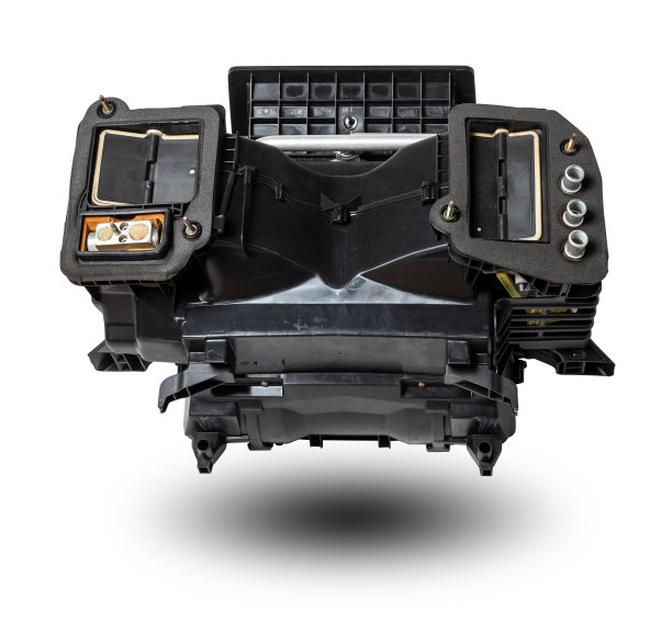 在车间的一辆汽车上，黑色塑料制成的炉子加热器与空调系统进行维修和更换，背景为白色隔离。车辆备件目录。图片下载