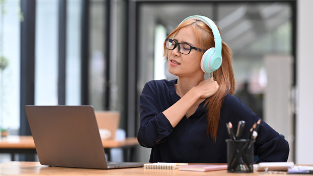 疲惫的商务女性按摩搓揉僵硬酸痛的颈部紧绷的肌肉，患颈部疼痛，工作姿势不正确。图片下载