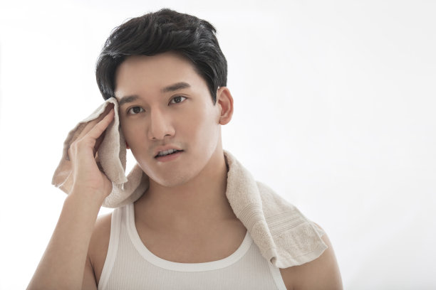 年轻的中国男子展示清洁产品，沐浴产品和身体护理产品-库存图片图片下载