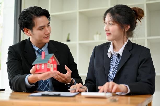 专业亚洲男性房地产经纪人与女性客户在办公室开会图片下载