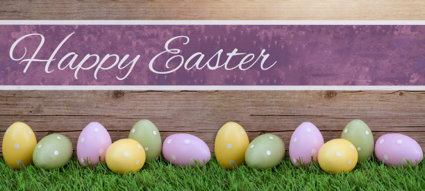 快乐的复活节背景全景贺卡-许多粉彩画点缀在新鲜的绿色草甸草地和质朴的木墙与空紫色粉红色的横幅复活节彩蛋图片下载