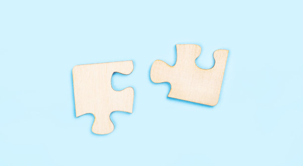 蓝色背景上的两块木制拼图。在团队合作中找到正确解决方案的概念。本空间图片下载