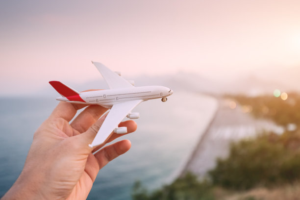 手握玩具飞机，背景是安塔利亚著名的Konyaalti海滩——土耳其主要的度假胜地和里维埃拉。旅客交通和航班梦想度假图片下载