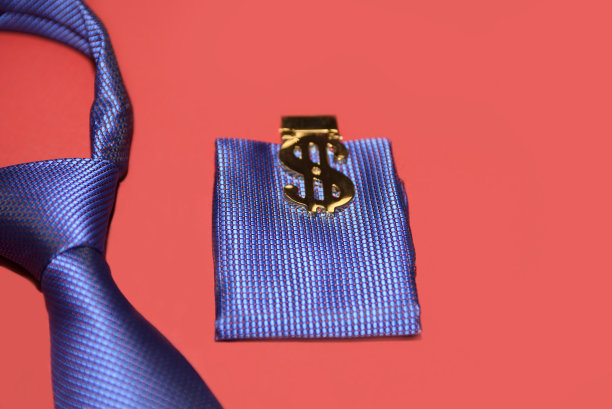 蓝色领带和手帕与夹子形式的美元图标在猩红色的背景。男人的配件特写。图片下载