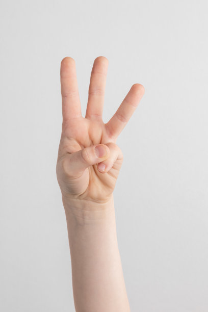 孩子的手在白色和灰色的背景下计数和显示三个手指图片下载