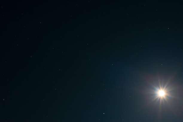 夜空背景下的月亮像一颗大星星在黑色的天空上闪耀着一颗星星。夏夜的天文照片图片下载
