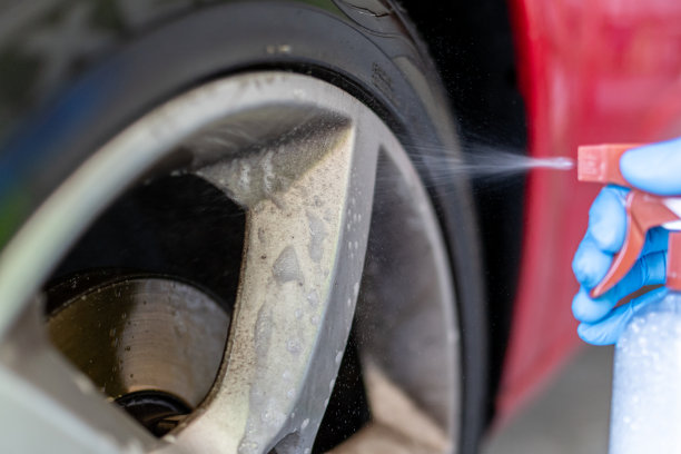手戴蓝色手套，用喷雾清洗车轮图片下载