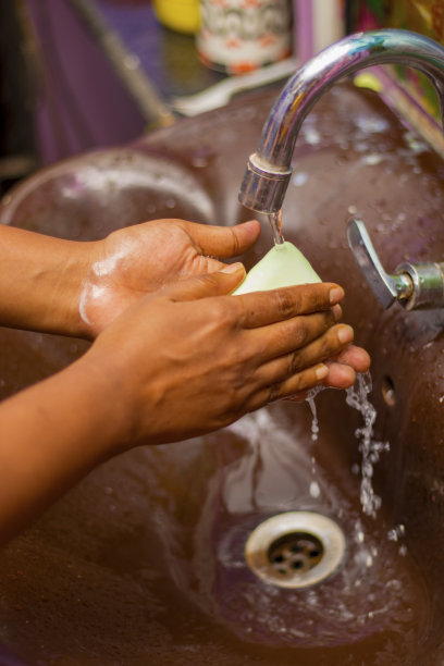 选择性聚焦一个小男孩在脸盆上洗手。图片下载