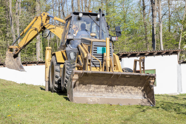 春天，挖掘机在乡间挖土图片下载