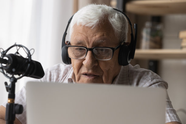 年长男子参与在线直播，对着麦克风讲话图片下载