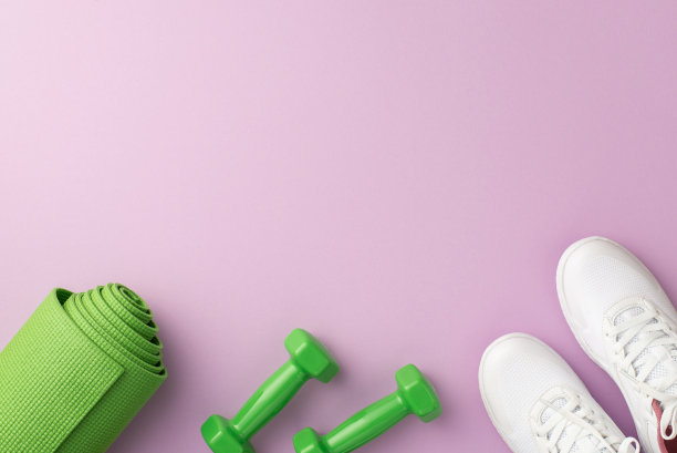 健康的概念。顶视图照片的绿色运动垫子哑铃和白色鞋子在孤立的粉彩紫罗兰色背景与空白图片下载