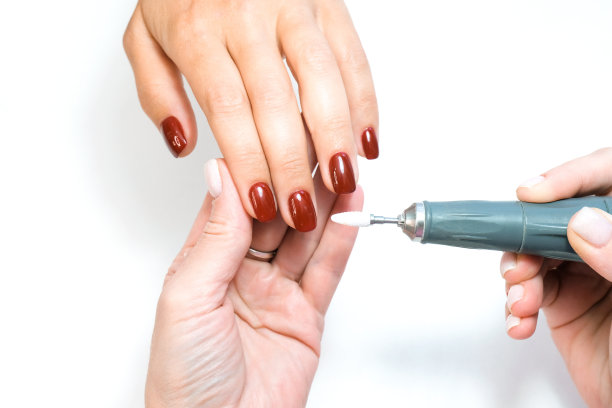 美容师沙龙,修指甲。美容院采用电机专业五金修甲。师傅使用电动机器去除手上的指甲油图片下载