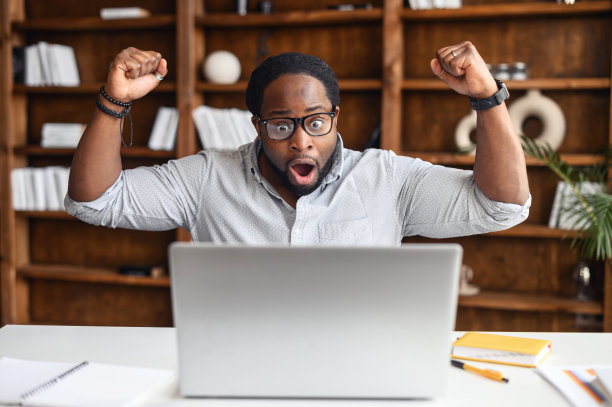 欣喜若狂的拉丁黑人商人在笔记本电脑上得到了压倒性的消息图片下载