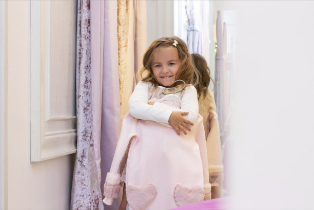 一个女孩在一家服装店的试衣间里试穿衣服。图片下载