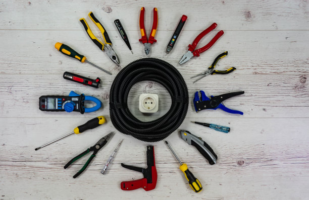 专业电动工具周围的波纹管和电源插座。前视图。浅色的背景。图片下载