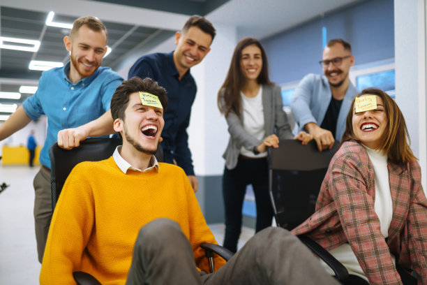 欢快的年轻人在办公椅上奔跑，大笑。图片下载