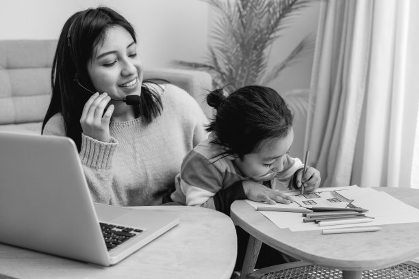 快乐的亚洲母亲在家里工作与她的孩子儿子-家庭概念-黑白编辑图片下载