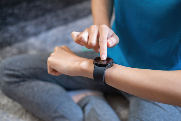 缓解压力，放松肌肉，练习呼吸，锻炼，冥想。女性使用智能手表来记录运动数据。图片下载