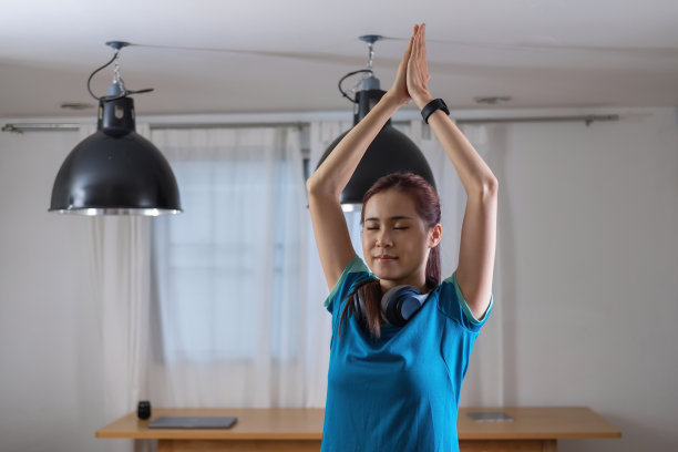 缓解压力，放松肌肉，练习呼吸，锻炼，冥想。女人在度假时在家练习瑜伽和肌肉。图片下载