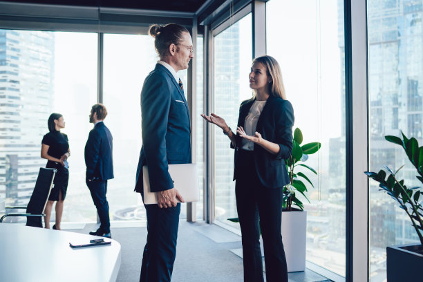 微笑的同事在会议室讨论工作问题图片下载