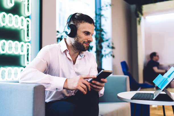 商人戴着耳机愉快地使用设备图片下载