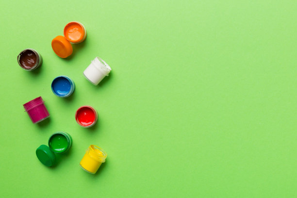 不同颜色的水粉罐在彩色的背景。爱好绘画。俯视图与空白的空间。工作场所的创造力。家庭教学概念图图片下载