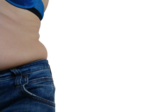 下垂的腹部。褶皱的皮革和垂在牛仔裤腰部两侧的脂肪。因暴饮暴食或怀孕而发胖的身材肥胖和糖尿病。白色背景。脂肪团松弛的肌肉图片下载
