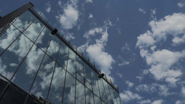 天空和建筑的玻璃立面。蓝天白云在玻璃墙上的倒影。城市摩天大楼。现代玻璃建筑和建筑。图片下载