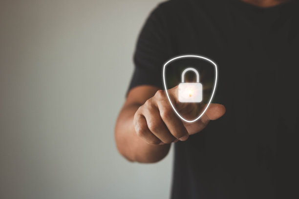 人触摸虚拟按钮一个带锁符号的盾牌，关于安全、网络安全和防范危险的概念图片下载