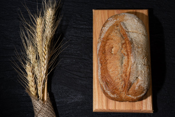 新鲜出炉的自制小麦面包，黑色的混凝土背景图片下载