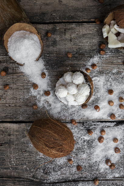 椰子糖，球，椰子和榛子放在质朴的木质表面图片下载
