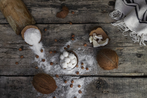 椰子糖，球，椰子和榛子放在质朴的木质表面图片下载
