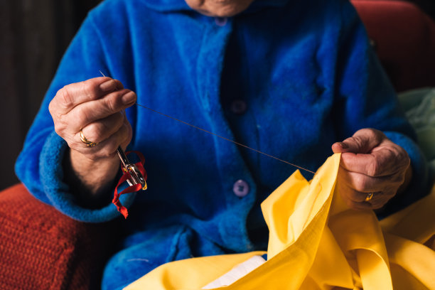 面目全非的奶奶在家缝长袍。概念独立的老年人和退休爱好。图片下载