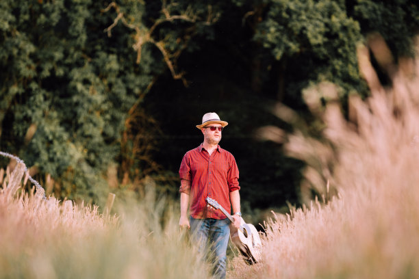 流浪的人在大自然中行走，背着原声吉他图片下载