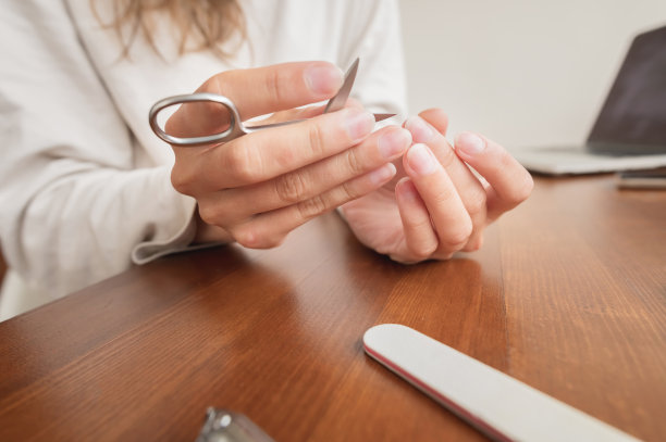 特写白人年轻女子在家里用指甲用品做美甲的手。图片下载