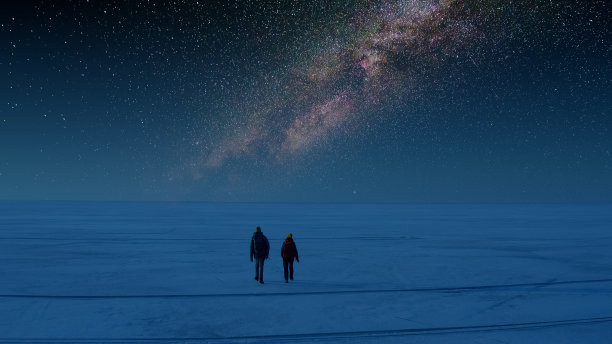 两名游客在星空背景下走过雪地图片下载