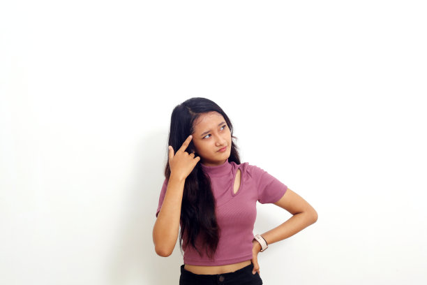 思考年轻的亚洲女人孤立的照片在白色背景看一边。图片下载