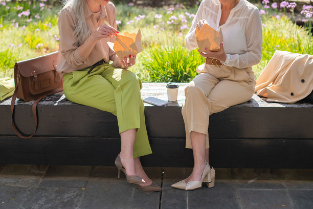 裁剪的商业女性在户外吃午餐的图像图片下载