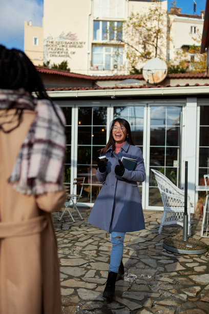 一个快乐的年轻女子在咖啡馆遇见她的女性朋友。聚会,大学的友谊。图片下载
