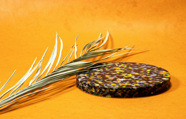 橙色背景上有棕榈叶的大理石空木板。春天和复活节的模拟设计图片下载