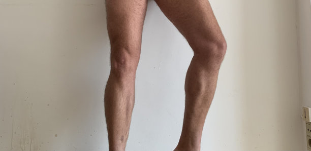 光着腿站在白墙上。图片下载