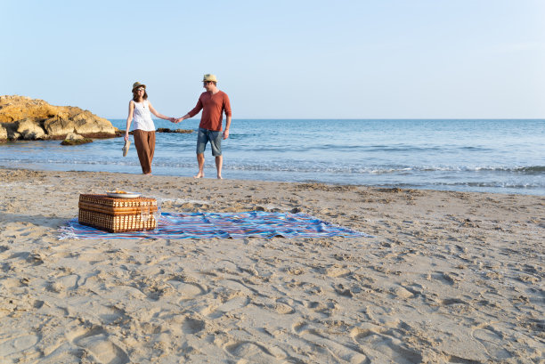 夕阳下的浪漫野餐后，一对夫妇在地中海海滩享受他们的时光。图片下载