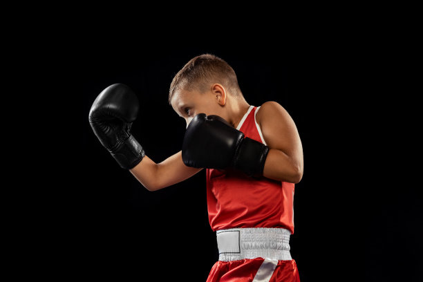 初学拳击的少年，在黑暗的背景下独自训练。运动、运动、学习、成就、生活方式的概念。图片下载