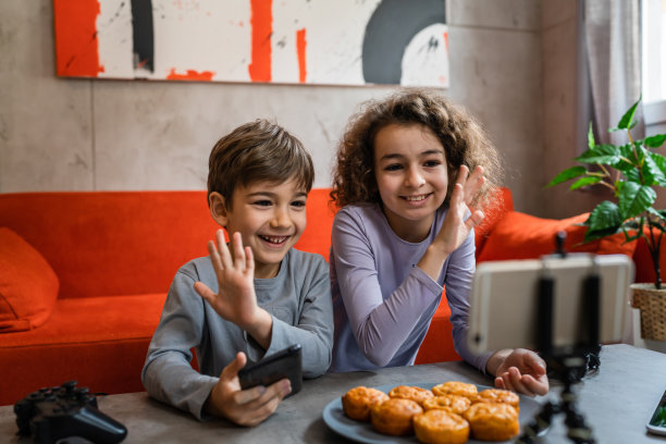 男孩和女孩两个兄妹兄妹制作视频博客在手机上在线互联网博客从他们的家最喜欢的玩具评论创建和分享内容的社交网络拷贝空间图片下载